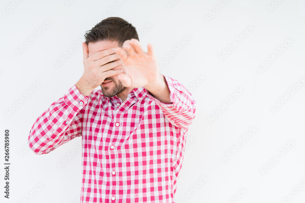 Young handsome man wearing shirt over isolated background covering eyes with hands and doing stop gesture with sad and fear expression. Embarrassed and negative concept. Young handsome man wearing shirt over isolated background covering eyes with hands and doing stop gesture with sad and fear expression. Embarrassed and negative concept.
