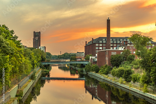 Photography The Teltow Canal in Berlin-Tempelhof, Germany, overlooking bridges and old factory buildings in the light of the setting sun