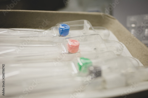 Intravenous cannula of different sizes, colour coded, on a tray in the hospital. 