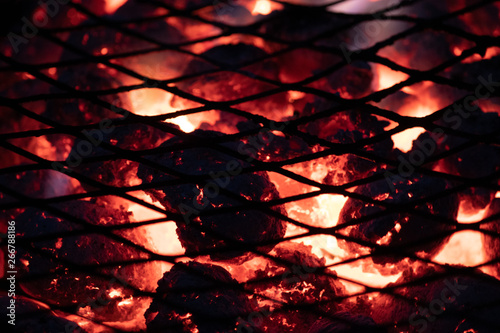 abstract red background with burning coals in bbq grill