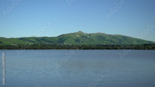 Water movement of the lake in the foreground, and in the background green hills. Static frame close-up. Shot on lake Elizabeth in Fremont, California, USA.