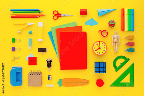 Collection of school supplies on yellow background.