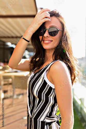 Obraz na płótnie Happy energy woman with dark hair wearing sunglass enjoying summer hot day on the rooftop w salonie