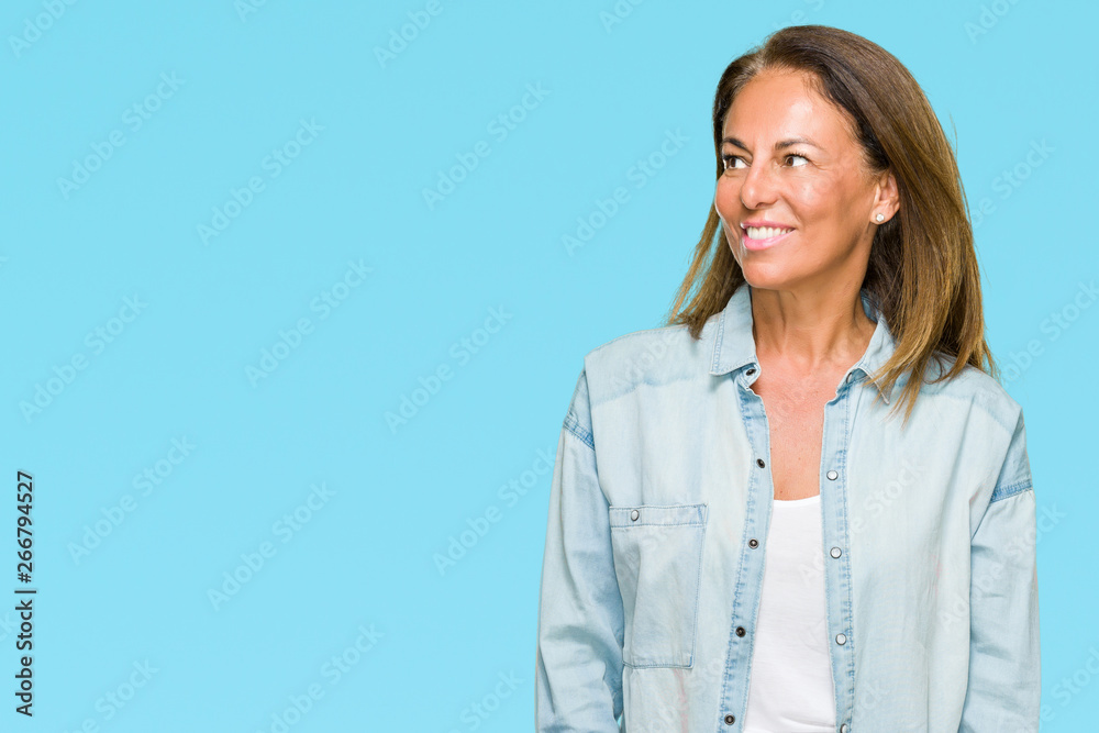 Middle age adult woman wearing casual denim shirt over isolated background looking away to side with smile on face, natural expression. Laughing confident. Middle age adult woman wearing casual denim shirt over isolated background looking away to side with smile on face, natural expression. Laughing confident.