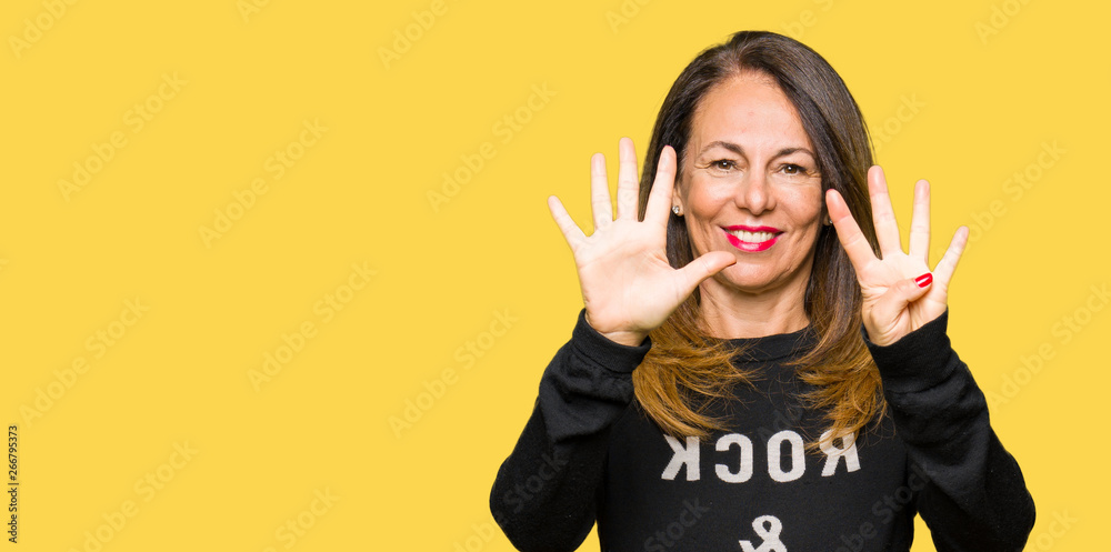 Beautiful middle age woman wearing rock and roll sweater showing and pointing up with fingers number nine while smiling confident and happy.