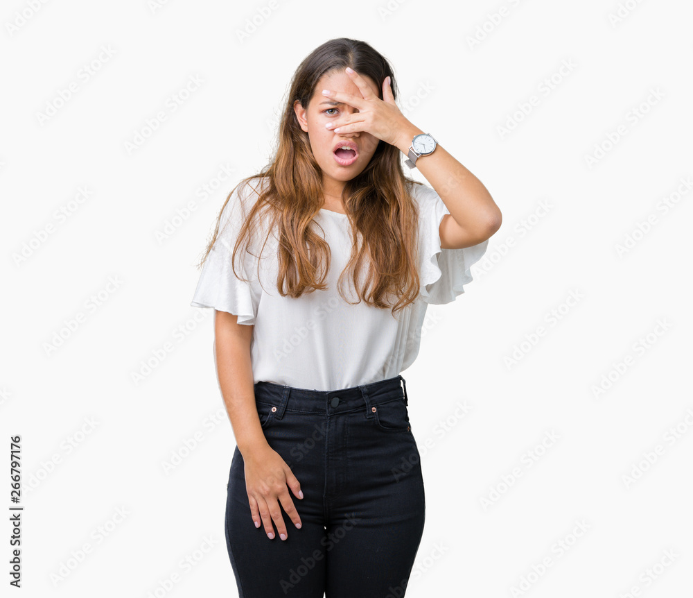Young beautiful brunette business woman over isolated background peeking in shock covering face and eyes with hand, looking through fingers with embarrassed expression. Young beautiful brunette business woman over isolated background peeking in shock covering face and eyes with hand, looking through fingers with embarrassed expression.