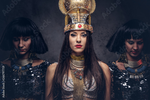 Photos Portrait of haughty Egyptian queen in an ancient pharaoh costume with two concubines