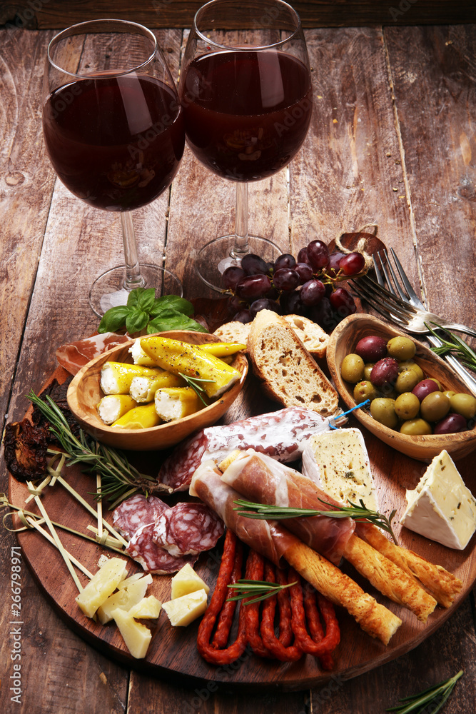 antipasto various appetizer. Cutting board with prosciutto, salami, cheese, bread and olives on dark wooden background antipasto various appetizer. Cutting board with prosciutto, salami, cheese, bread and olives on dark wooden background