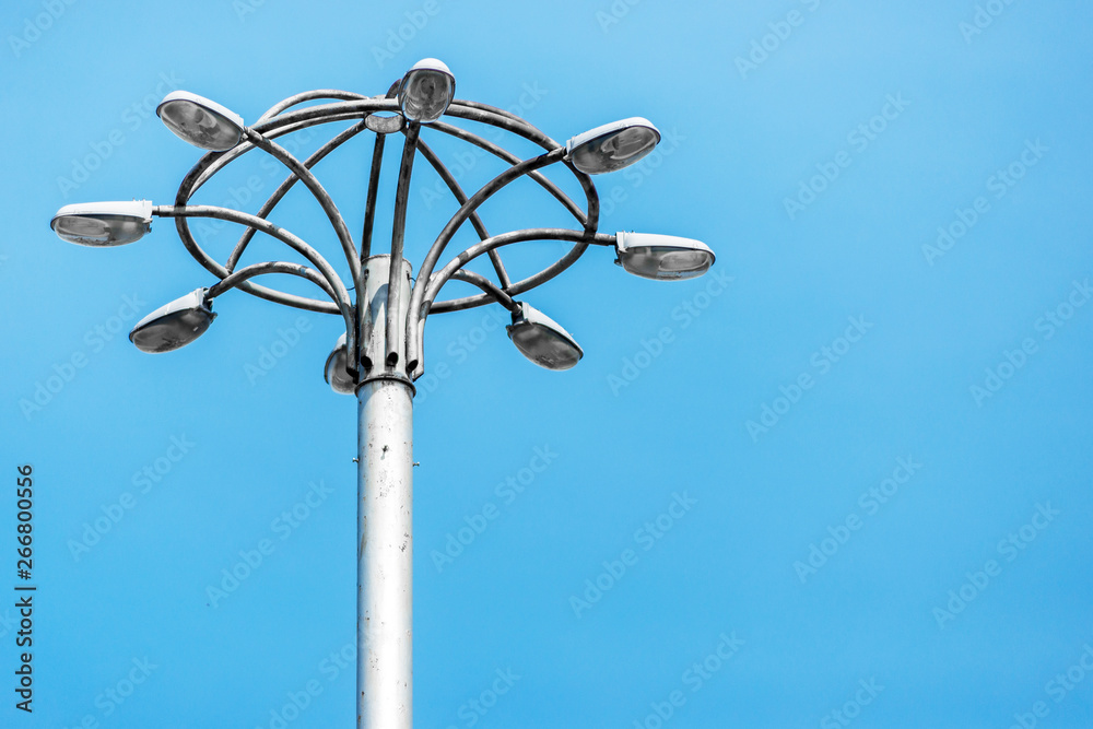 Tall old city lamppost stands against blue sky Tall old city lamppost stands against blue sky