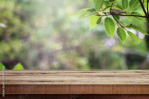 Wooden table and blurred green nature garden background.