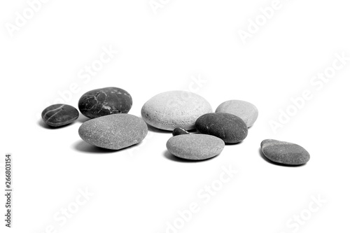 Scattered sea pebbles. Heap of smooth gray and black stones isolated on white background