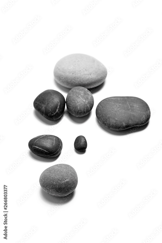 Scattered sea pebbles. Heap of smooth gray and black stones isolated on white background Scattered sea pebbles. Heap of smooth gray and black stones isolated on white background