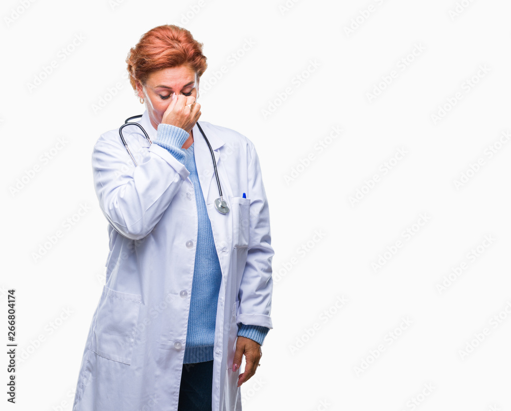 Senior caucasian doctor woman wearing medical uniform over isolated background tired rubbing nose and eyes feeling fatigue and headache. Stress and frustration concept. Senior caucasian doctor woman wearing medical uniform over isolated background tired rubbing nose and eyes feeling fatigue and headache. Stress and frustration concept.