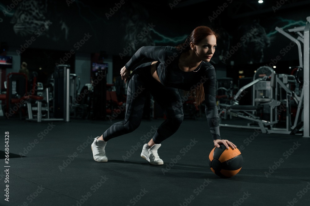 Slim woman in sportswear training with a ball Slim woman in sportswear training with a ball