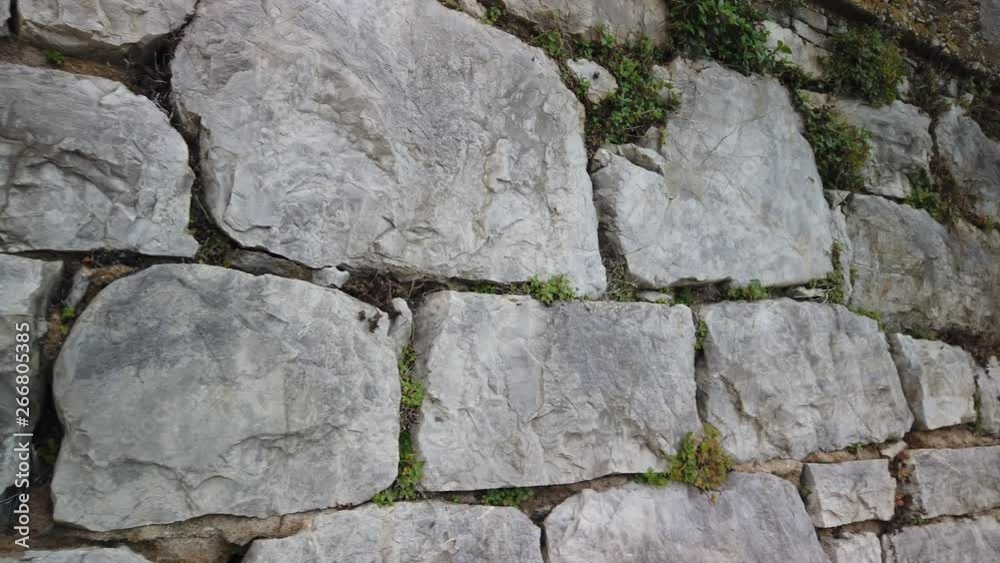 Panning shot across large boulder, stone build wall alongside Lovran, Croatia waterfront promenade views. Panning shot across large boulder, stone build wall alongside Lovran, Croatia waterfront promenade views.