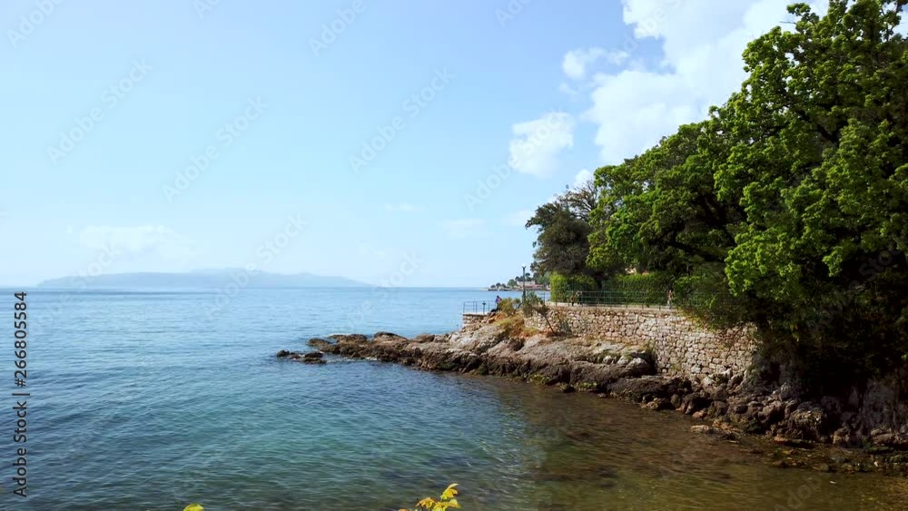 Slow panning view across natural rocky terrain coastal pathway overlooking picturesque seascape of Lovran, Croatia. Slow panning view across natural rocky terrain coastal pathway overlooking picturesque seascape of Lovran, Croatia.