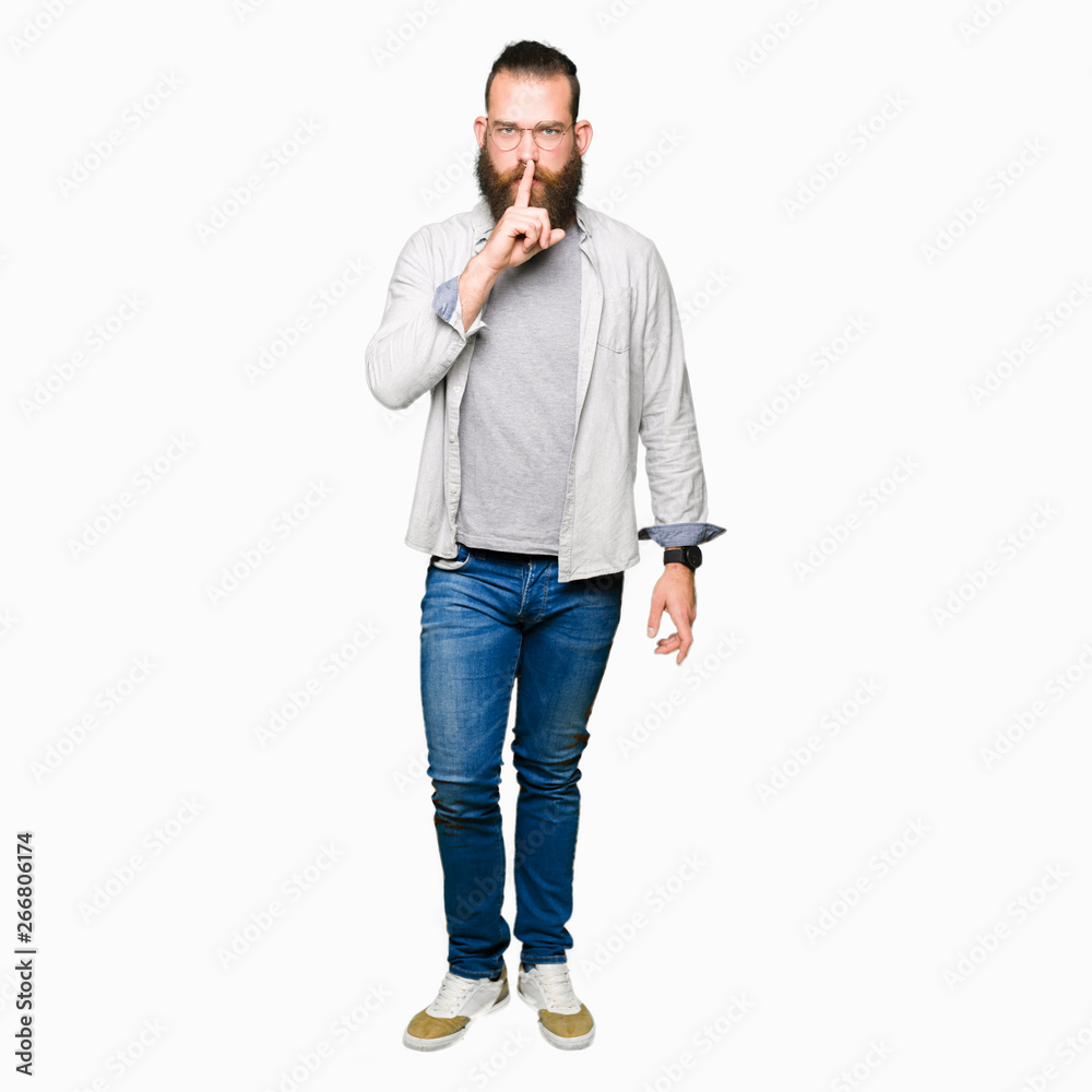 Young blond man wearing glasses asking to be quiet with finger on lips. Silence and secret concept. Young blond man wearing glasses asking to be quiet with finger on lips. Silence and secret concept.
