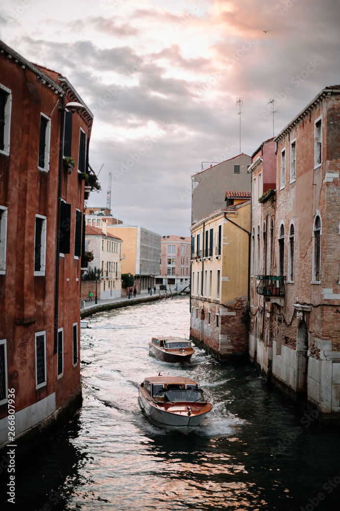 two boats drive down the canal in venice italy