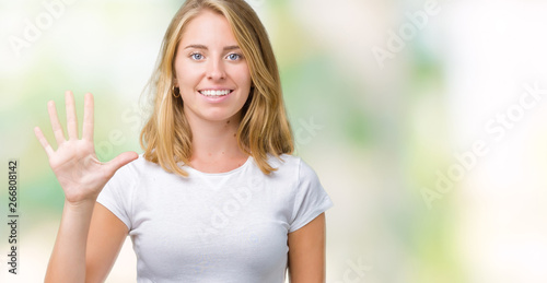 Beautiful young woman wearing casual white t-shirt over isolated background showing and pointing up with fingers number five while smiling confident and happy. © Krakenimages.com