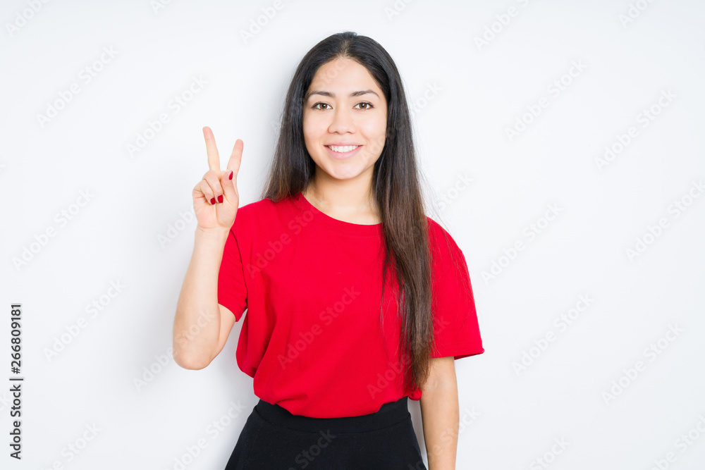 Beautiful brunette woman wearing red t-shirt over isolated background showing and pointing up with fingers number two while smiling confident and happy. Beautiful brunette woman wearing red t-shirt over isolated background showing and pointing up with fingers number two while smiling confident and happy.