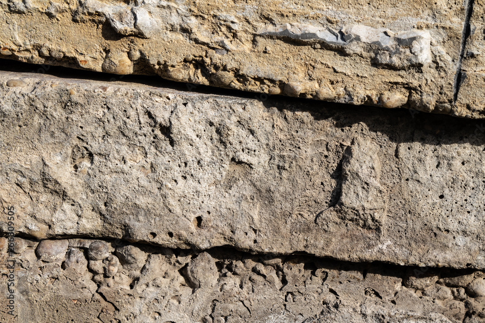 Fototapeta premium Rough limestone wall texture background with stacked stone blocks.