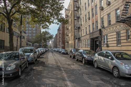 Beautiful landscape view of one of one of streets in Brighton beach neighborhood. Yellow buildnings and parked cars. Beautiful landscape backgrounds. © Alex
