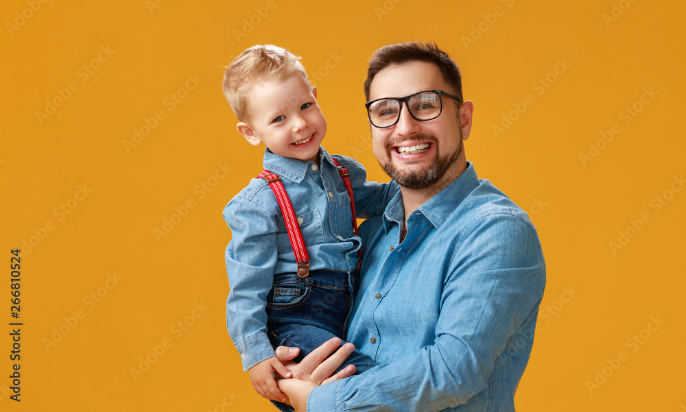 happy father's day! cute dad and son hugging on yellow background ...