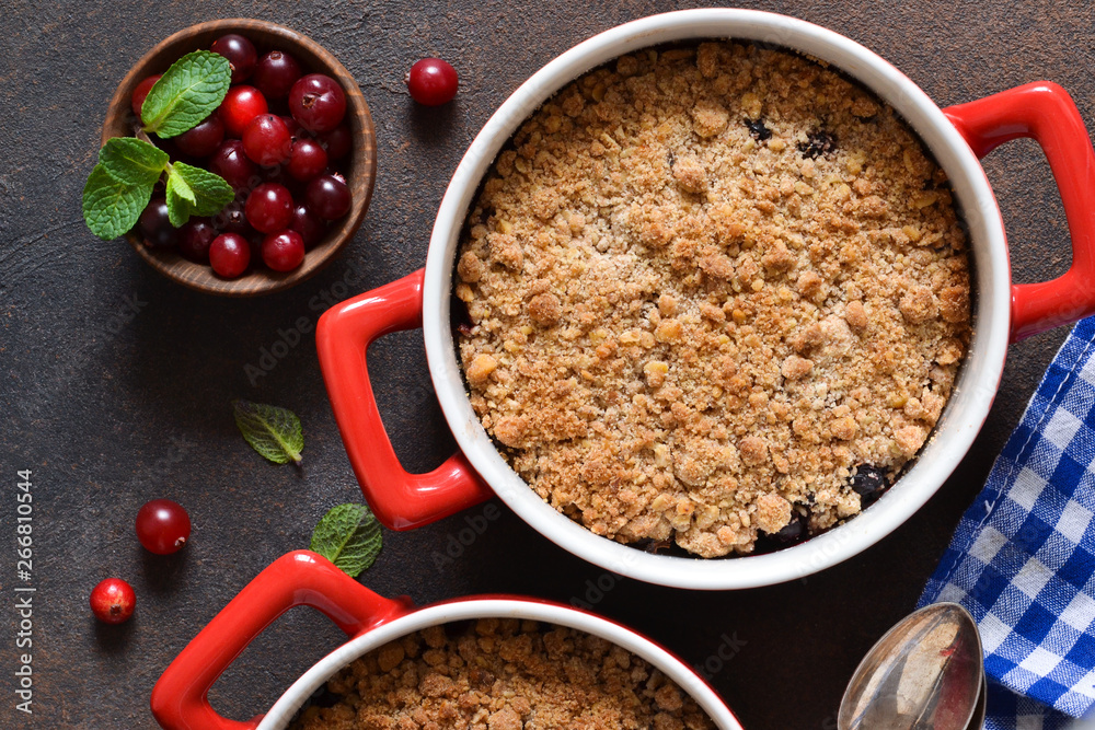 Crumble with cranberries and other berries, nuts on the kitchen table. View from above. Crumble with cranberries and other berries, nuts on the kitchen table. View from above.