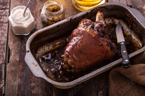 Baked Pork knuckle with beer and cauliflower in roast pan.