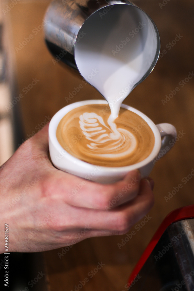 Fototapeta barista przygotowujący kawę (cappuccino), nalewający mleko