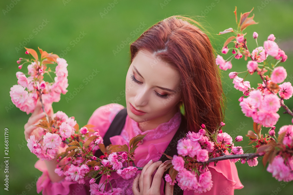 Beautiful woman in the garden of sakura. Retro clothes, pink blouse. Beautiful woman in the garden of sakura. Retro clothes, pink blouse.