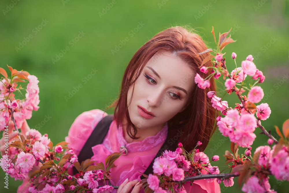 Beautiful woman in the garden of sakura. Retro clothes, pink blouse. Beautiful woman in the garden of sakura. Retro clothes, pink blouse.