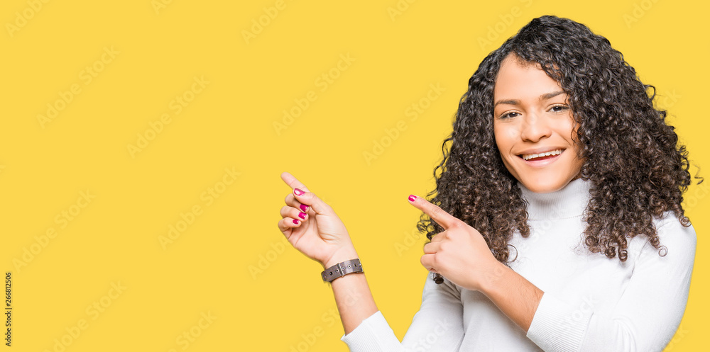 Young beautiful woman with curly hair wearing turtleneck sweater smiling and looking at the camera pointing with two hands and fingers to the side. Young beautiful woman with curly hair wearing turtleneck sweater smiling and looking at the camera pointing with two hands and fingers to the side.