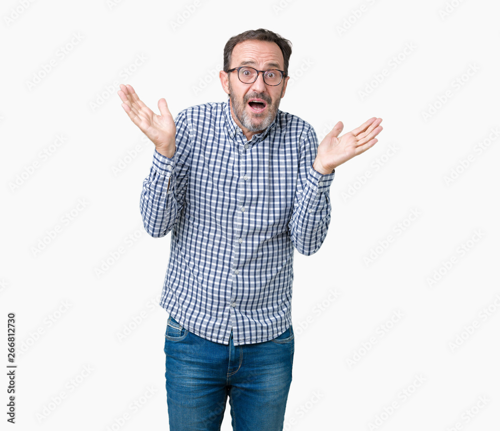 Handsome middle age elegant senior business man wearing glasses over isolated background clueless and confused expression with arms and hands raised. Doubt concept. Handsome middle age elegant senior business man wearing glasses over isolated background clueless and confused expression with arms and hands raised. Doubt concept.