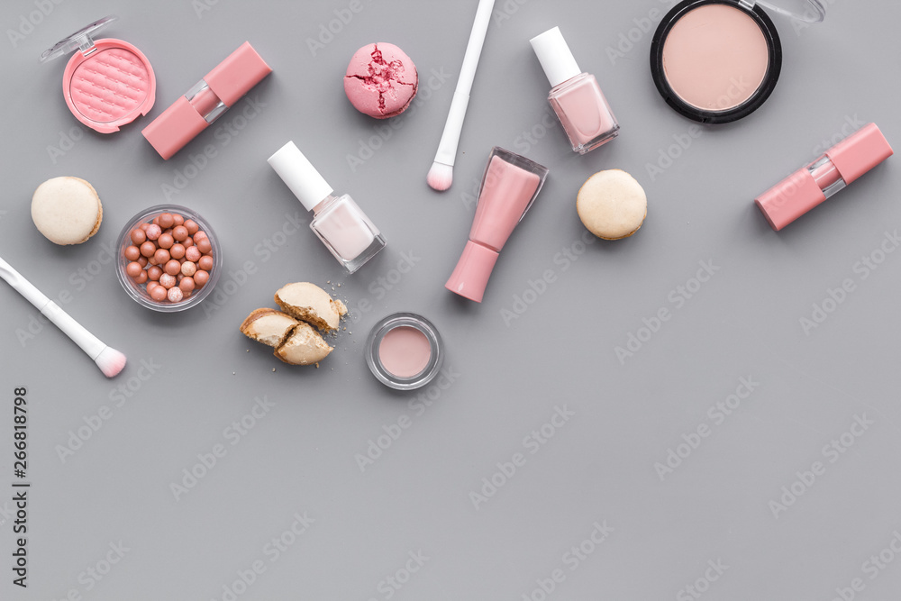 decorative cosmetics for make-up with macaroon cookies on gray tabletop background space for text decorative cosmetics for make-up with macaroon cookies on gray tabletop background space for text