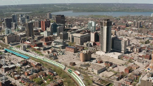 Hamilton Ontario Canada 4k Aerial Drone of Skyline Downtown Core of City During Sunny Day. GO Train, Lake Ontario and Business District Visible As Camera Moves Backwards and Tilts Up