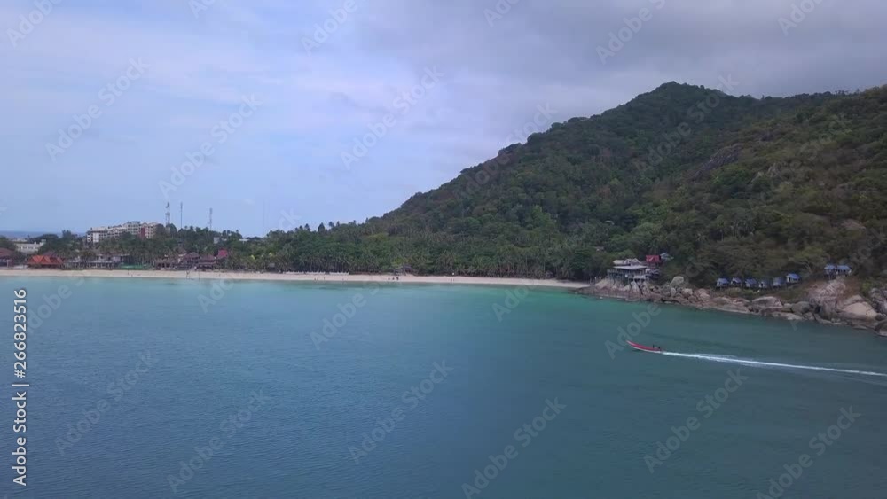 Thai long tail taxi boat moves around tropical island Thai long tail taxi boat moves around tropical island