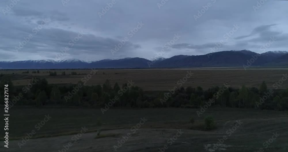 Uimon Valley in Altai, with fields and hay on it, at sunset Uimon Valley in Altai, with fields and hay on it, at sunset