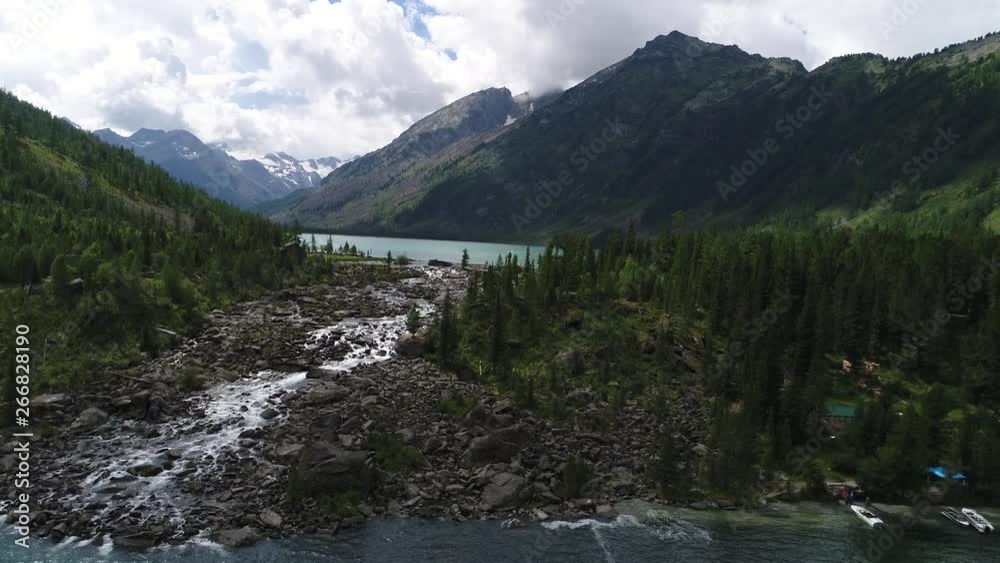 Turquoise lakes with a small waterfall between them, among the Altai Mountains Turquoise lakes with a small waterfall between them, among the Altai Mountains