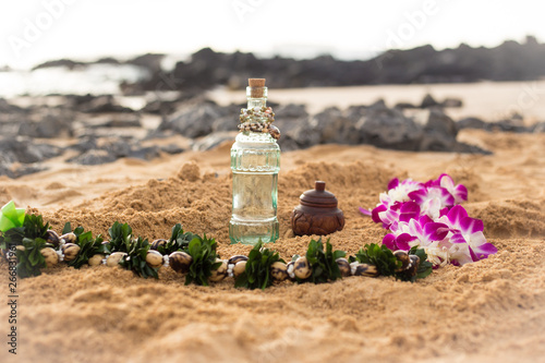 Lei and ceremony bottles on beach