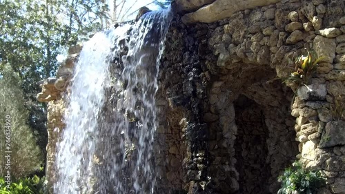 Waterfall splashing over river rocks.