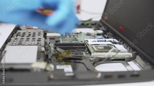 Time-lapse of mounting new parts in a laptop by a professinal technician with thermal paste and protective gloves. photo