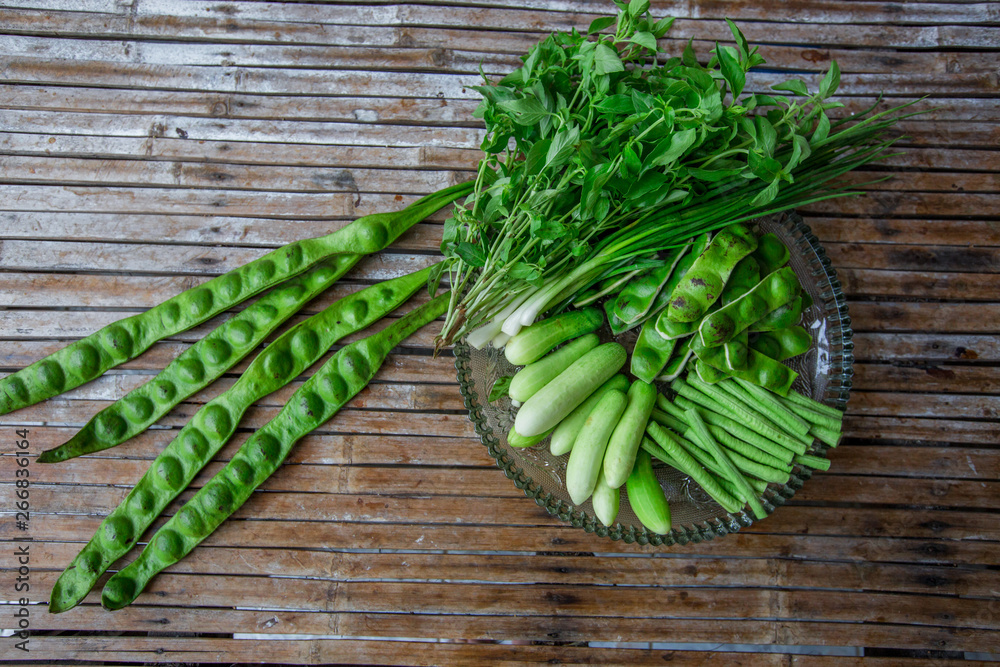 A view of the arrangement of a close-up food set,a healthy vegetable set (cucumber,sato,long-hatched bean)that is placed in a beautiful container and placed on a wooden stick to serve customers again.