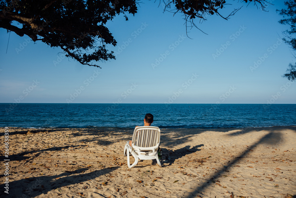Man sitting on chair on the beach