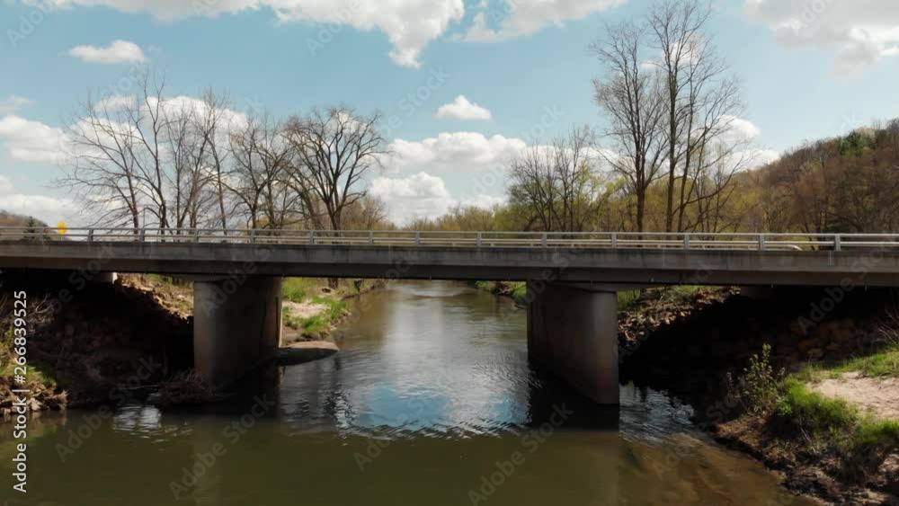 Fly over of a bridge revealing a river in early spring Fly over of a bridge revealing a river in early spring