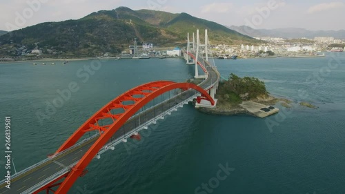 A car passing through the Sacheon Bridge, a sea cable car behind it, panorama drone shot photo