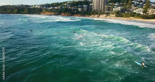 Surfers entering the sea on their surfing lesson.