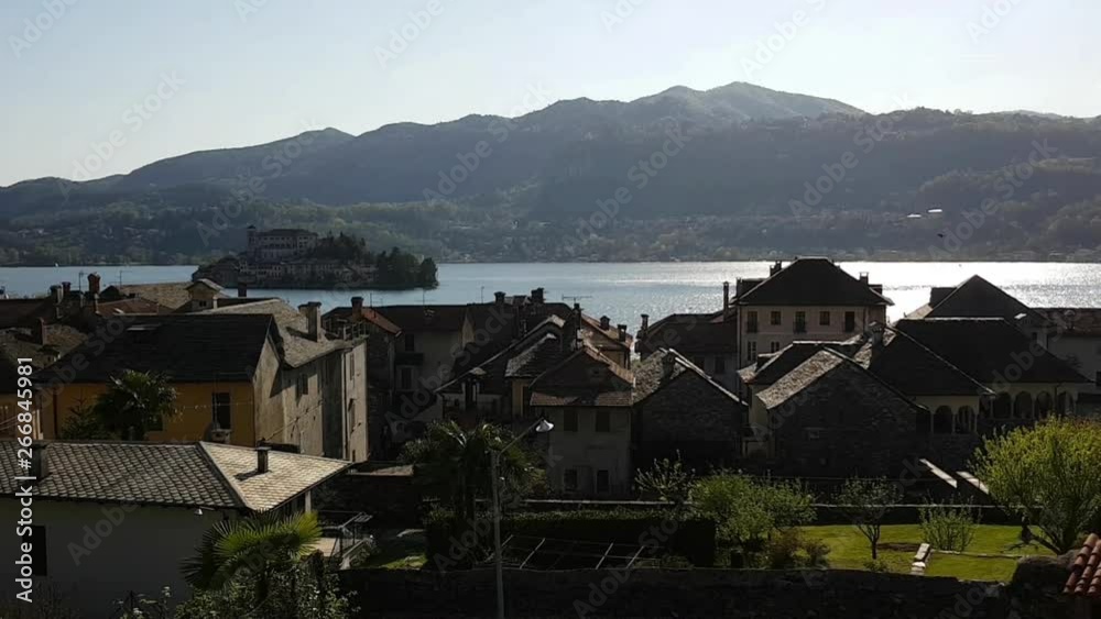 The small italian village of Orta San Giulio and the little San Giulio island on the Orta lake in a spring day . Realtime video The small italian village of Orta San Giulio and the little San Giulio island on the Orta lake in a spring day . Realtime video