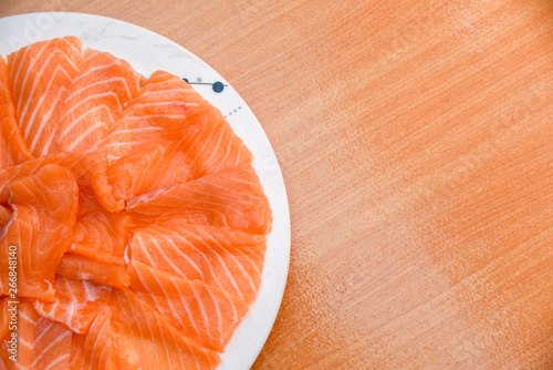 Closeup top view Slided Raw Salmon in white dish on wood blackground