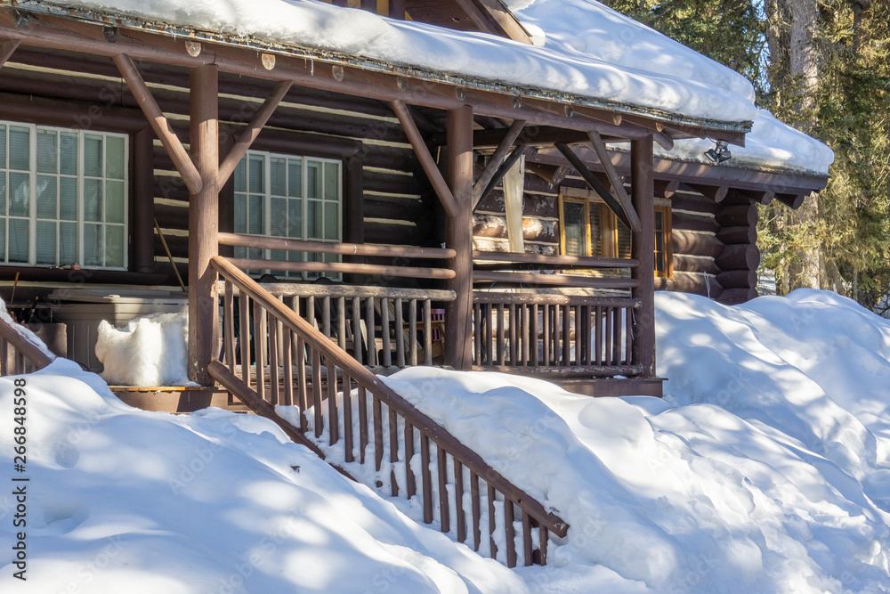 wooden house covered in snow in the early spring woods alberta canada. wooden house covered in snow in the early spring woods alberta canada.